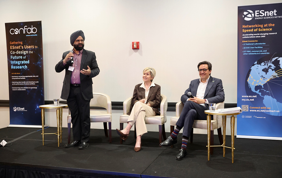 Three researchers in business attire speaking in a conference room with white walls.