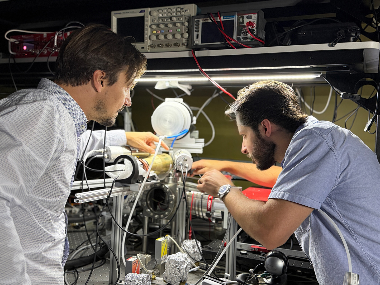 Two people work on equipment in a lab.