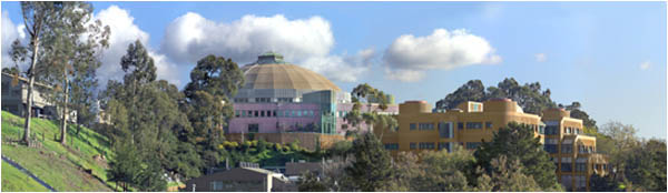 The Advanced Light Source in front of a blue, cloud-filled sky.