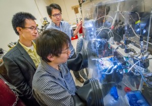 Peidong Yang (left), Hao Ming Chen and Chong Liu (glove box) have developed the first fully integrated nanoscale artificial photosynthesis system. (Photo by Roy Kaltschmidt)